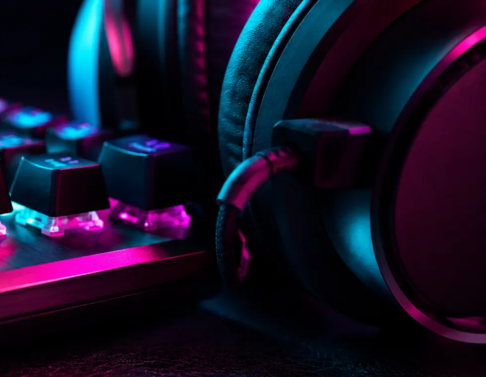 Detalle de teclado mecánico y audífonos con luces RGB